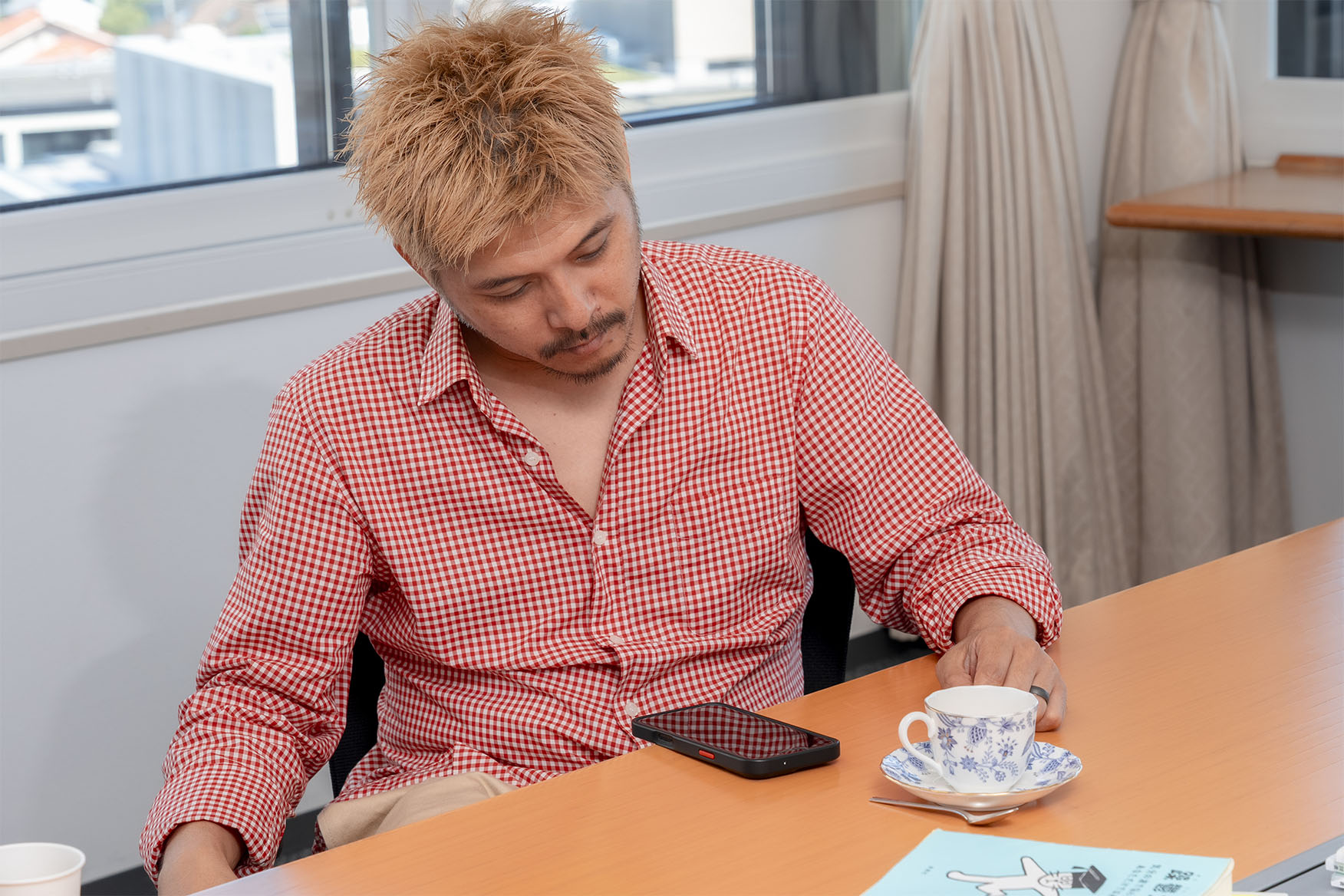 インタビュー中にかかってきた「いのっちの電話」に出る坂口さん。　画像